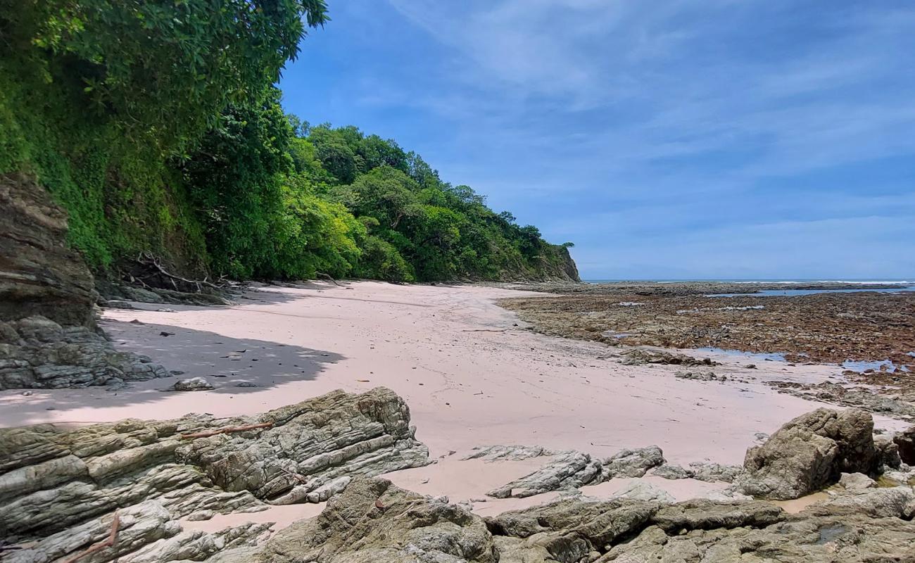 Foto de Playa Rosada con arena brillante y rocas superficie