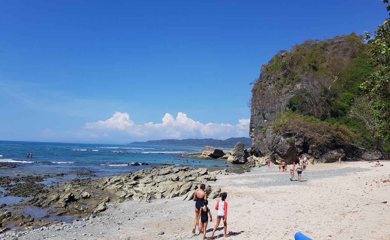 Foto de Playa Cuevas con arena brillante y rocas superficie