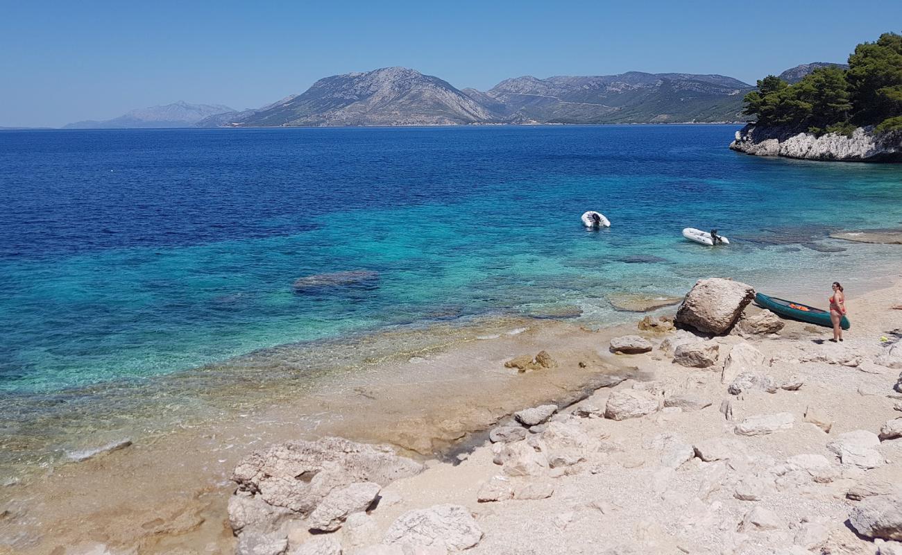 Foto de Secret Beach Zuljana con arena brillante y rocas superficie