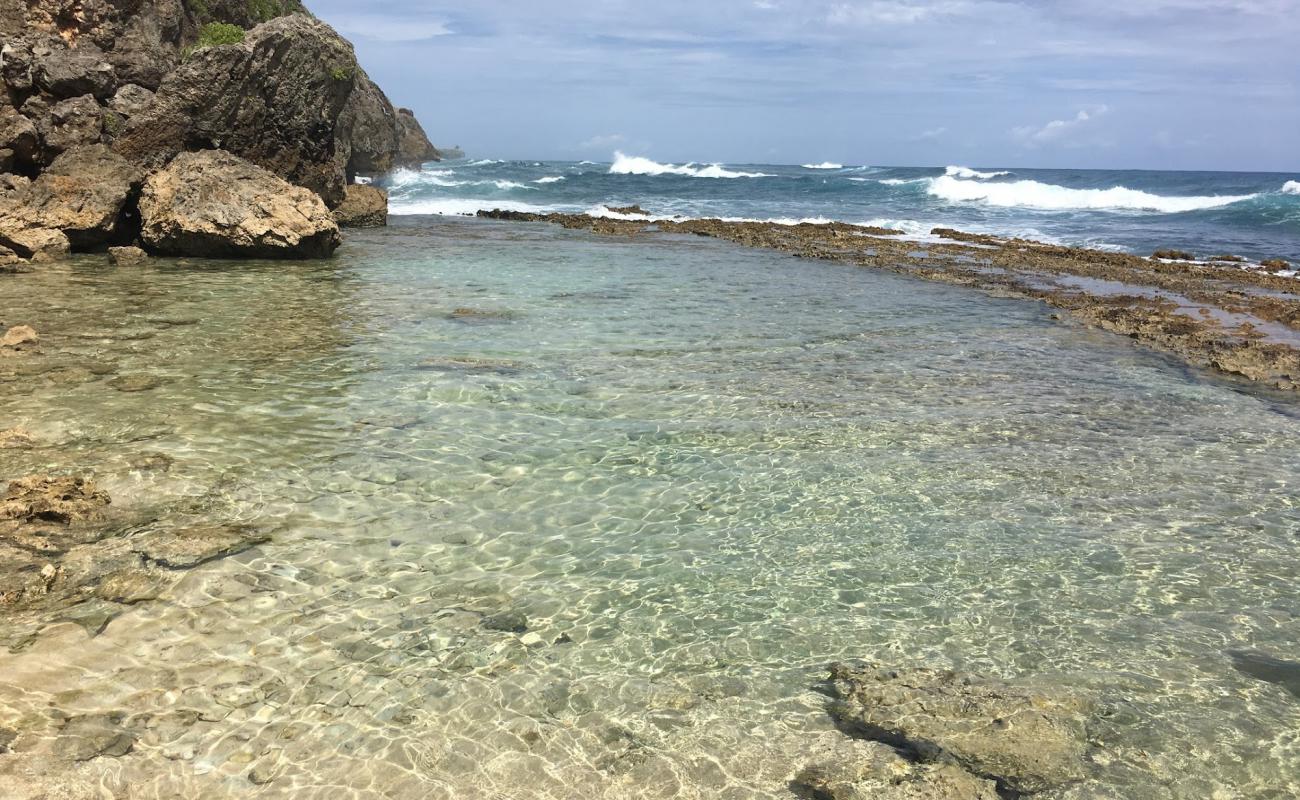 Foto de Playa Caleton Pequeña con arena brillante y rocas superficie