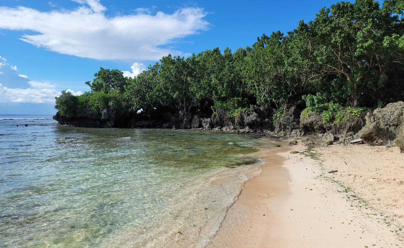 Foto de Tanguisson Beach con arena brillante y rocas superficie