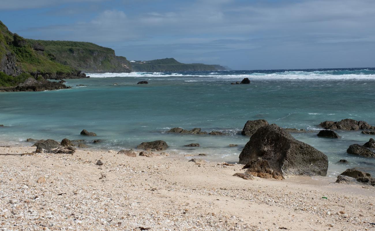 Foto de Taga'chang Beach con arena brillante y rocas superficie