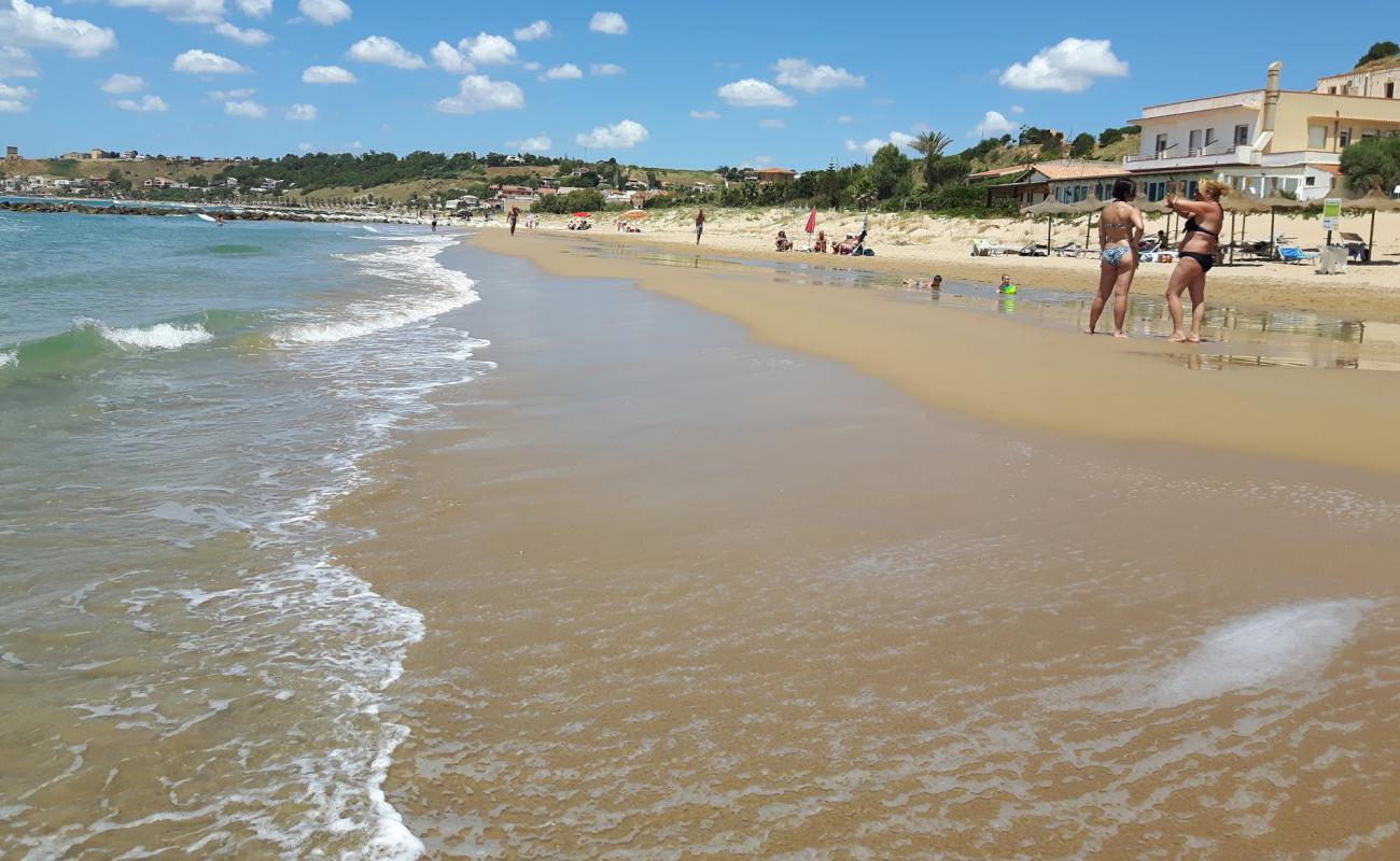 Foto de Porto Palo Beach con brillante arena fina superficie