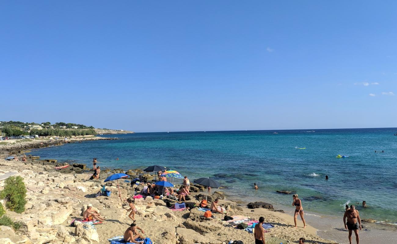 Foto de Felloniche Spiaggia con arena brillante y rocas superficie