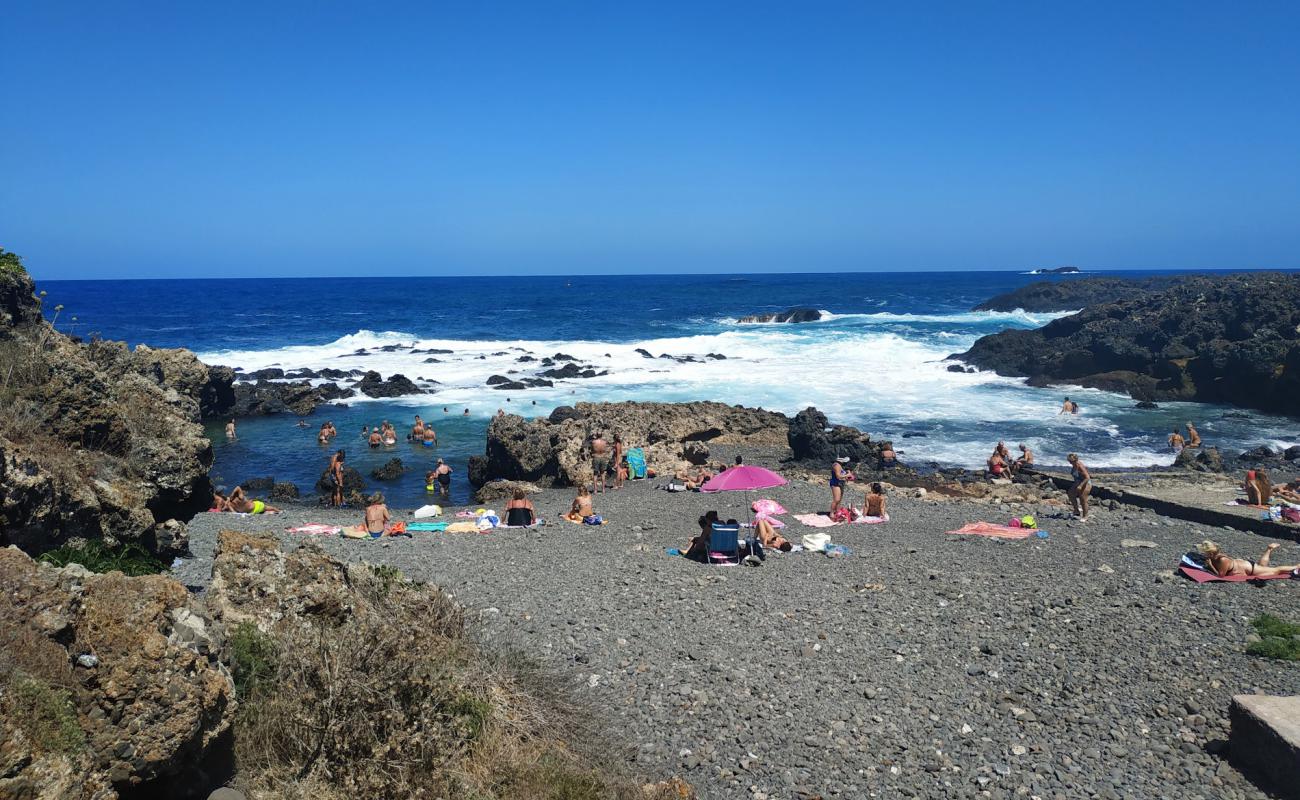 Foto de Caletta Acquario con arena gris y piedras superficie