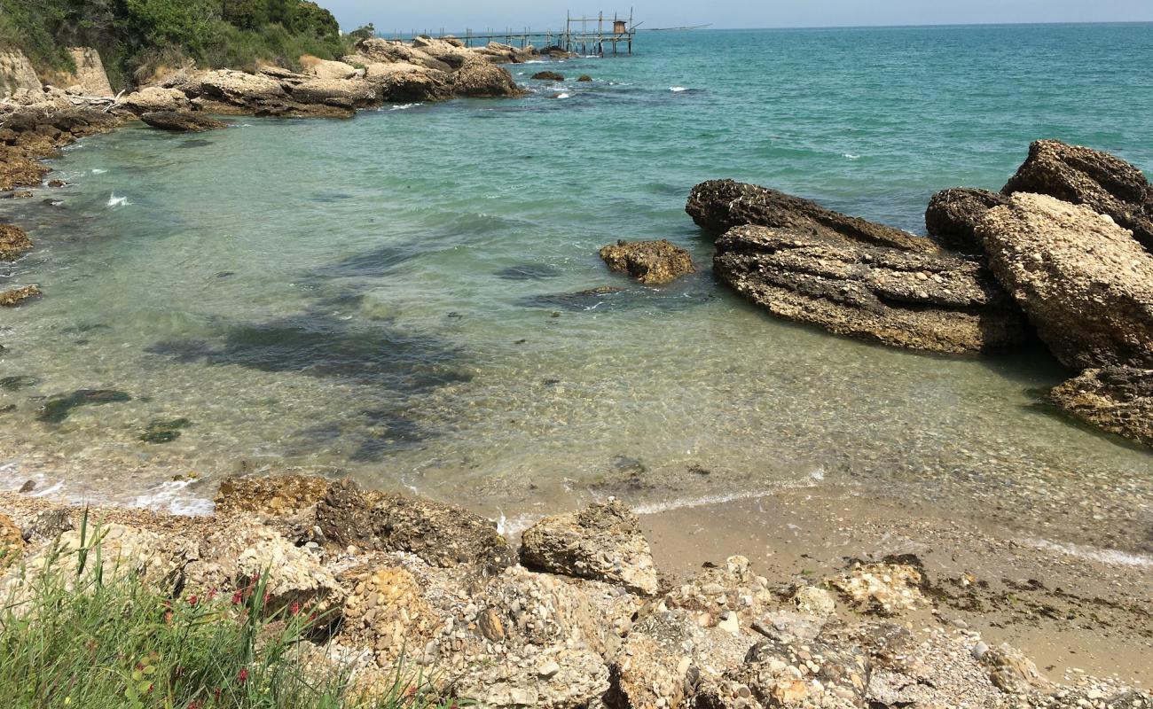 Foto de Spiaggia di Torricella con arena brillante y rocas superficie