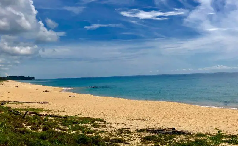 Foto de Pantai Teluk Bidara con arena brillante superficie