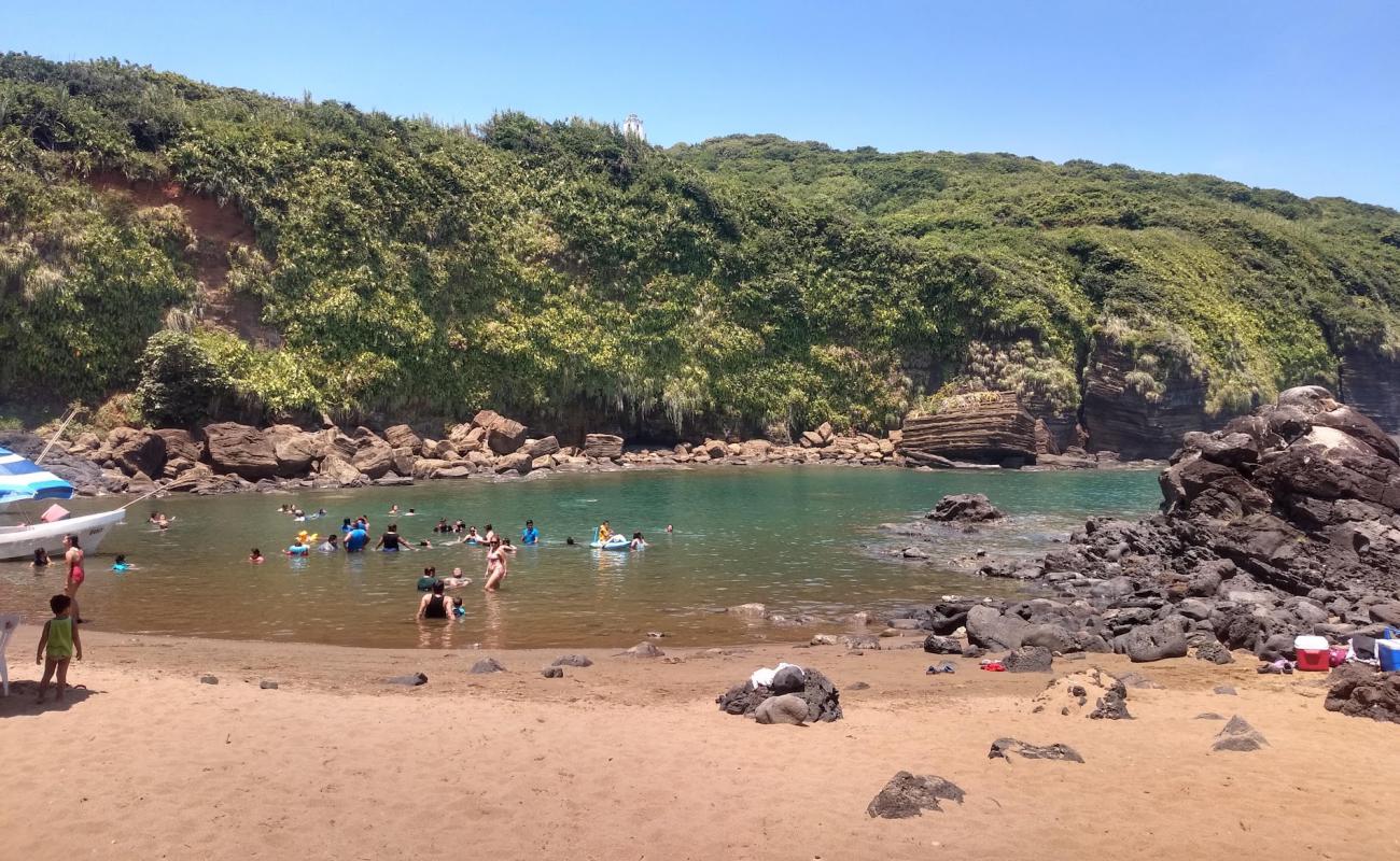 Foto de Playa Escondida con arena brillante y rocas superficie