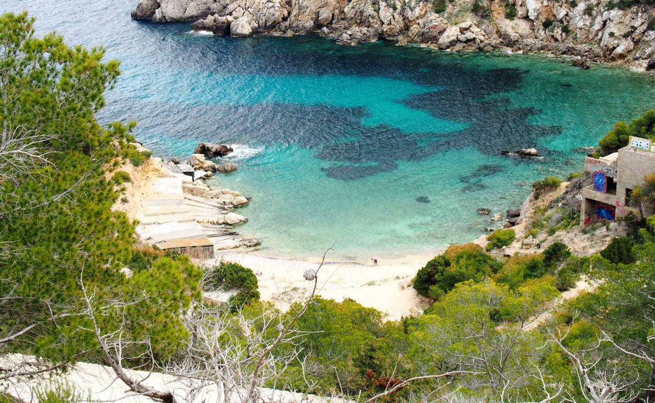 Foto de Cala D'en Serra con arena/piedras marrón superficie