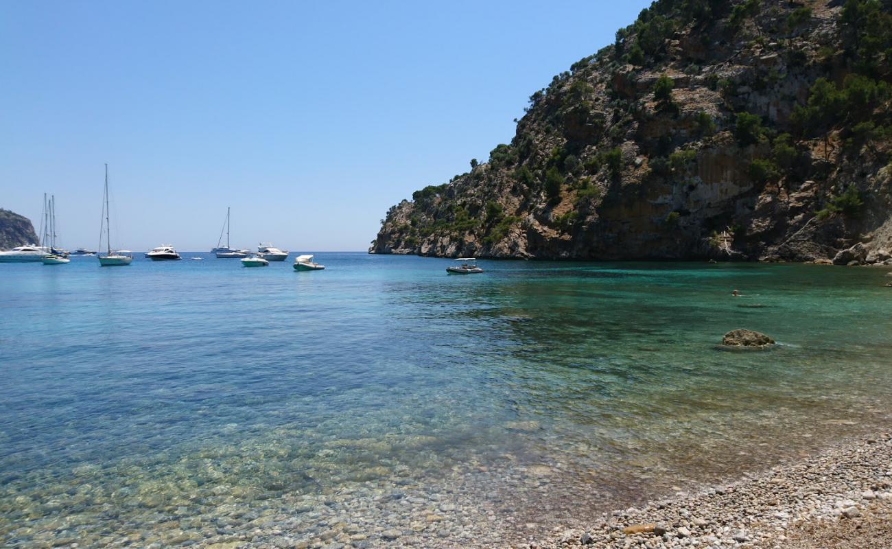 Foto de Cala Blanca con arena gris y piedras superficie