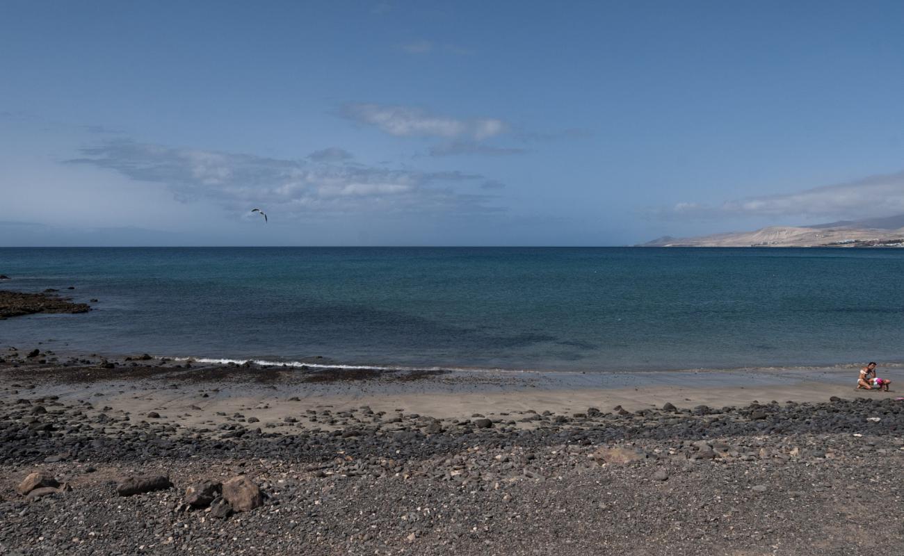 Foto de Playa de la Jaqueta con arena/piedras marrón superficie