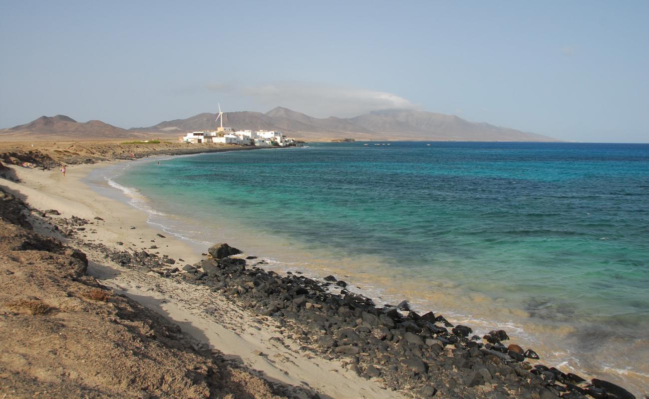 Foto de Playa "El Puertito" con arena brillante y rocas superficie