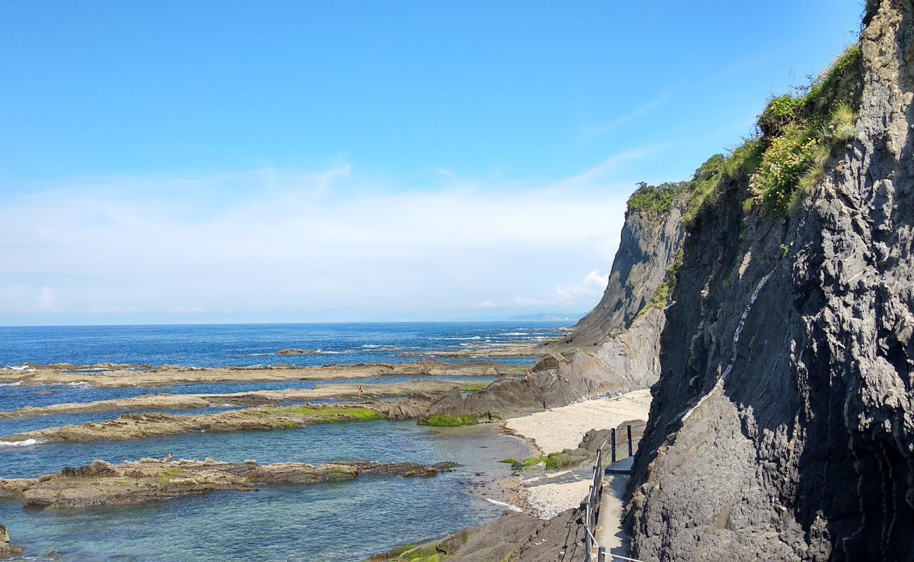 Foto de Ondarroa Nudista Beach con arena brillante y rocas superficie