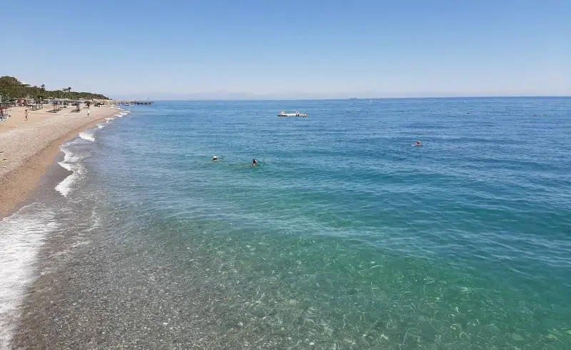 Foto de Playa de Goynuk III con arena/guijarros negro superficie